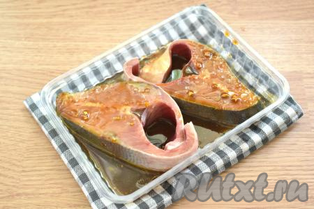 Стейки горбуши выкладываем в подходящую тару (я взяла пластиковый контейнер) и заливаем получившимся маринадом. Горбушу маринуем 20 минут, пару раз за это время переворачиваем кусочки рыбы.